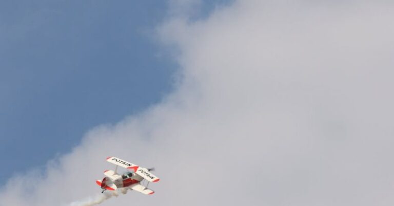 Aerial Tricks - White and Red Biplane Flying during White Cloudy Day